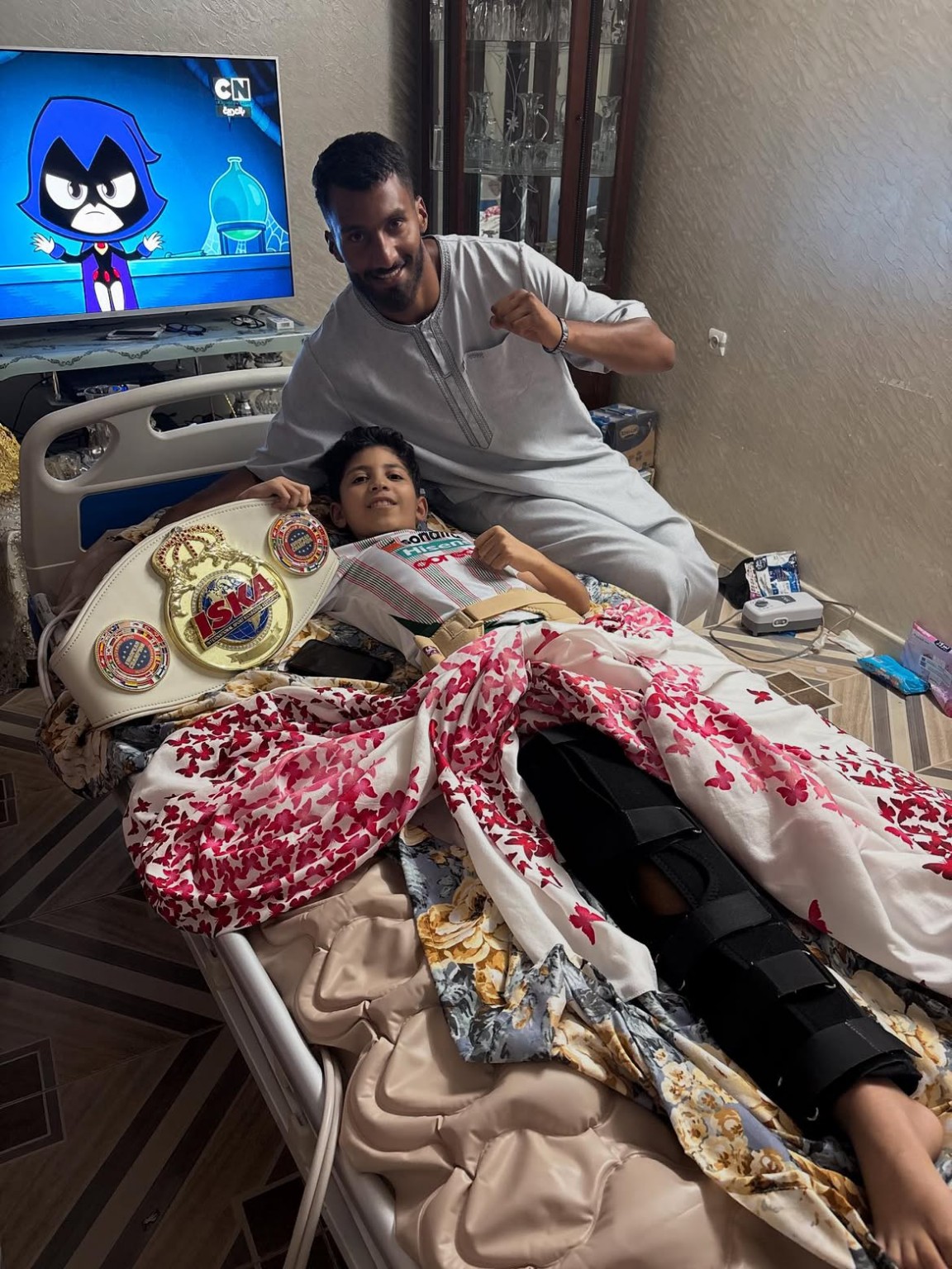 Abdelrahmane Rezzag rend visite à un enfant et lui montre sa ceinture
