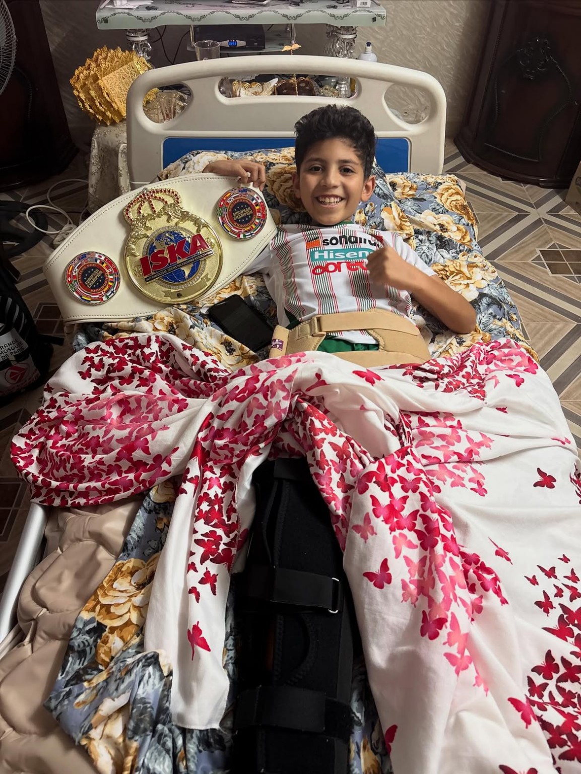 Un enfant souriant auprès de la ceinture présentée pendant la visite